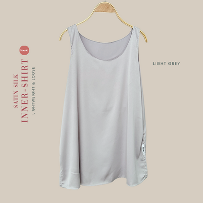 A light grey satin silk sleeveless inner shirt displayed on a wooden hanger.