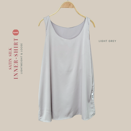 A light grey satin silk sleeveless inner shirt displayed on a wooden hanger.